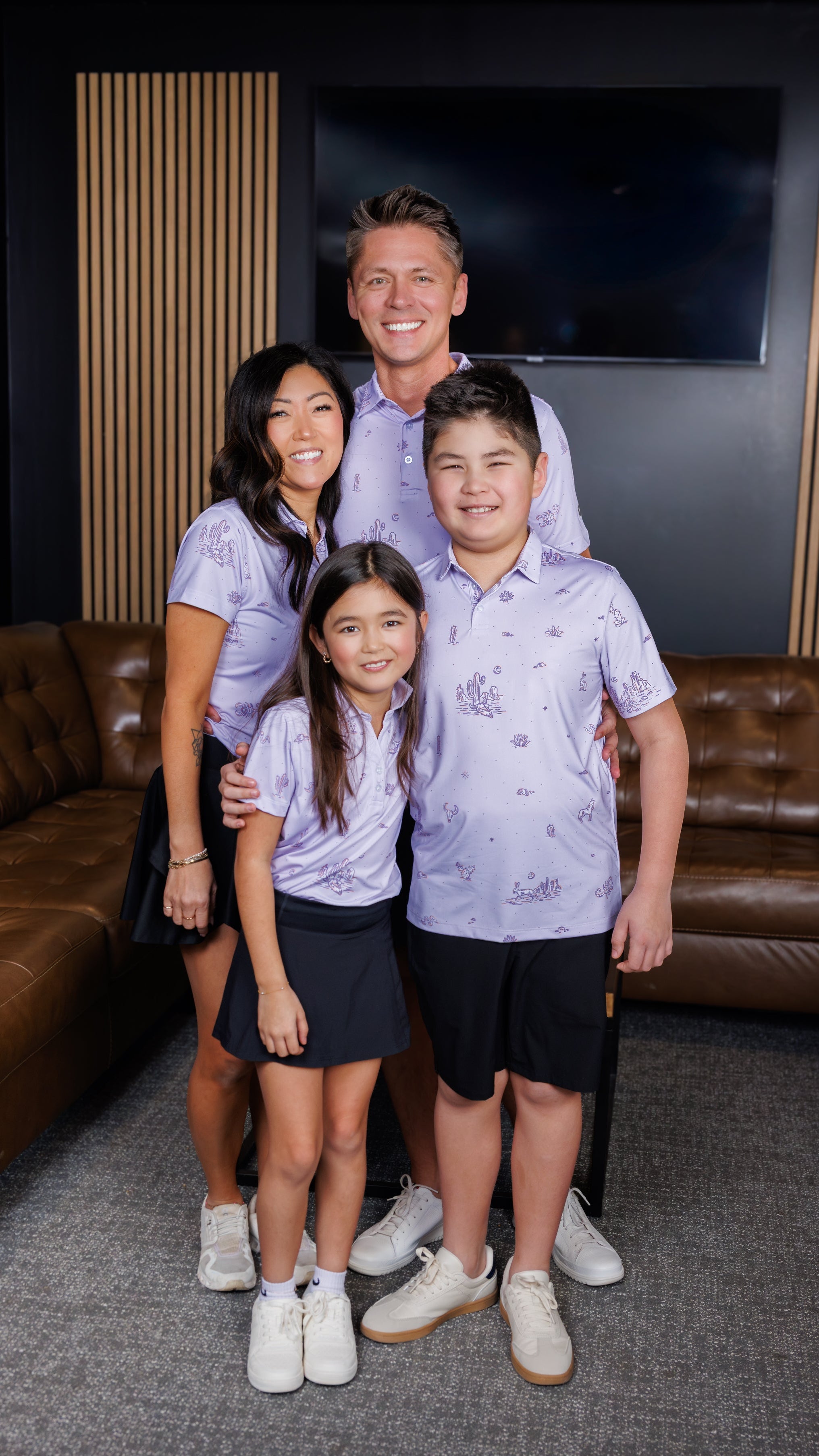 Family wearing matching Dry Heat Polos while at a golf simulator.