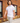 Male Model wearing the Fresh Picked Pique Polo walking down a sidewalk with a brick building in the background