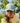 A female model wearing the Fresh Tracks Flight Hat outside with greenery & blue sky in the background