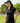 Model wearing the Loon Lake 2.0 Pique Polo on the golf course with greenery in the background