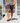 Model wearing the Daydrift shorts walking down a dock with the lake in the background
