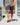 Model wearing the Daydrift shorts walking down a dock with the lake in the background