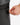 Close up on the Zippered pocket on the left leg of the Ace Pants on a model in front of a white background