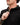Person wearing a black jacket with a brand logo, close-up of the jacket and hand.