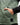 Close up on the left pocket and Waggle Rubber patch on the Balsam Crosscut Vest on a model in front of a light gray background
