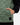 Close up on the left pocket and Waggle Rubber patch on the Balsam Crosscut Vest on a model in front of a light gray background