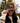 Model wearing the Bird Dog Waxed Canvas Hat outside doing a hat tilt with greenery in the background.