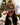 Model wearing the Bird Dog Waxed Canvas Hat outside doing a hat tilt with greenery in the background.