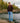 Male Model wearing the Bird Dog Wildknit Sweater next to a body of water with rocks in trees in the background.