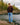 Male Model wearing the Bird Dog Wildknit Sweater next to a body of water with rocks in trees in the background.