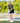 Female model wearing the Bird Dog Club T-Shirt outside on a mini golf course with greenery in the background
