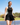 Model wearing the Black Crossover Tank on the golf course with greenery and ultra blue sky's in the background