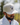 A male model wearing the Buck Up Hat outside with greenery in the background