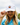A female model wearing the Coco Loco Flight Hat outside with clouds and greenery in the background