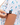 Waggle W logo on the left sleeve of the Downhill Polo on a model in front of a white background