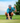 Model wearing the Triceraputts hat paired with the Extinct Polo lining up a put. The model is on a golf course with blue skys and green trees in the background