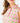 Close up on the collar of the Fairway Fiesta Sleeveless Polo on a model in front of a light gray background.