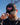 Model wearing the Flamingrove Hat doing a hat tilt with blue sky in the background.