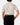 Back of the Fowl Play Polo tucked in on a model in front of a light gray background.