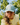 A female model wearing the Fresh Tracks Flight Hat outside with greenery & blue sky in the background