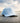 Freshwater Repel Hat sitting on a dock with water and sky in the background.