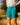 Model wearing the Green Lakers Shoreline Short on the shoreline of a lake.