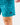 Close up on the Waggle W patch on the left leg of the Green Lakers Shoreline Short on a model in front of a light gray background.