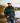 Male model wearing the Gunflint Sherpa Pullover outside on the shore of a lake with greenery in the background.