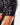 Close up on the Waggle Patch on the left sleeve of the High Roller Polo on a model in front of a light gray background.