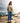 Female Model wearing the Highlander Wildknit Sweater outside on a rocky shoreline, with a lake in the background.