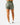 Back of the Hunter Green Momentum Shorts on a model in front of a light gray background.