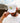 Model doing a hat tilt with the Husker Hat outside with blue sky in the background.