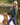 Female model wearing Wildknit Crewneck Sweater while standing by a pond with her dog.