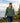 Model wearing the Moss Waffle Knit Hoodie outside walking up a set of stairs with a lake and trees in the background.