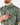 Close up on the left chest pocket on the Muskied Outpost Button-Down Shirt on a model in front of a light gray background.