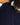 Close up on the Waggle "W" Badge on the back of the Navy Plume Funnel Neck on a model in front of a light gray background.