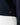 Close up on the Waggle Badge on the bottom of the Navy Plume Funnel Neck on a model in front of a light gray background.