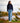 Model wearing the Navy Plume Funnel neck outside walking down a dirt path with a lake and trees in the background.