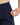 Close up on the Zippered pocket on the left leg of the Rhythm Pants on a model in front of a white background