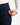 Close up on the Zippered pocket on the left leg of the Rhythm Pants on a model in front of a white background