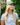 Female model wearing the Off Course Polo on the golf course with greenery in the background