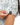 Waggle W logo on the left sleeve of the Off Course Polo on a model in front of a white background