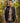 Model wearing the Onyx Crosscut Vest outside with greenery in the background