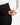 Close up on the Zippered pocket on the left leg of the Rhythm Pants on a model in front of a white background
