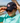 Model wearing the Pool Party Flight Hat outside by a lake with blue sky in the background
