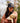 Model wearing the Rocky Waxed Canvas Hat outside looking down at a puppy, with greenery in the background.