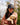 Model wearing the Rocky Waxed Canvas Hat outside looking down at a puppy, with greenery in the background.