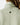Close up on the Waggle "W" Badge on the back of the Sage Plume Funnel Neck on a model in front of a light gray background.