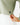 Close up on the Waggle Badge on the bottom of the Sage Plume Funnel Neck on a model in front of a light gray background.