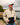 Model wearing the Sandstone Surge Pullover outside on a shoreline of a lake with water and trees in the background.